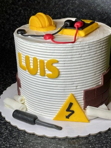 Pastel personalizado con temática de construcción, decorado con herramientas, señal de peligro y casco de obra.